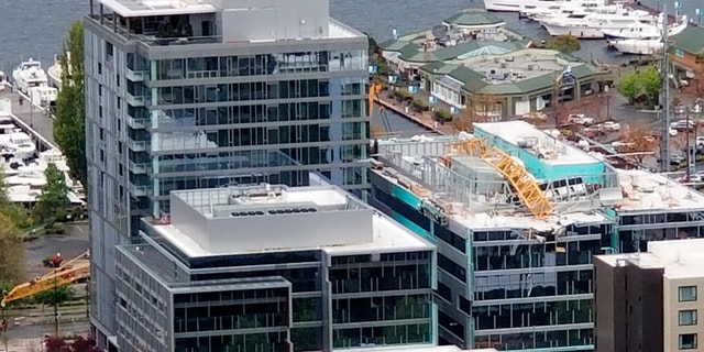 The falling crane, which had been situated on top of a building, damaged multiple cars, the department said.