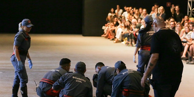 Model Tales Soares is caught on the podium by paramedics after her collapse at Sao Paulo Fashion Week in Sao Paulo, Brazil on Saturday, April 27, 2019. A statement from the organizers said that Soares had died as a result of an accident. illness while he was attending Sao Paulo Fashion Week. (Leco Viana / Thenews2 via AP)