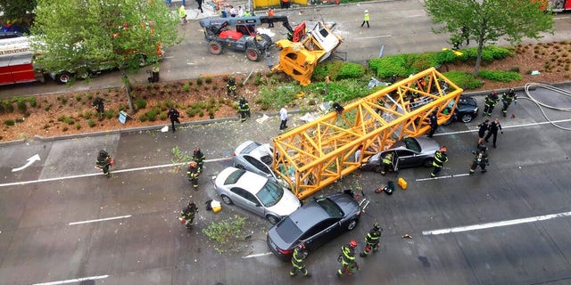 Firefighters and police team members work to clear the scene of a construction crane crashing from a building in Seattle's new Google campus, which collapses in one of the city's most busy city and killing several people Saturday.