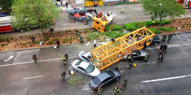 Fire and police crew members work to clear the scene where a construction crane fell from a building on Google's new Seattle campus crashing down onto one of the city's busiest streets and killing multiple people on Saturday.