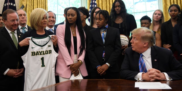Baylor women's basketball head coach Kim Mulkey, third from left, presents a jersey to President Trump as he welcomed members of the Baylor women's basketball team, who are the 2019 NCAA Division I Women's Basketball National Champions, to the Oval Office of the White House on April 29, 2019. (AP Photo/Susan Walsh)