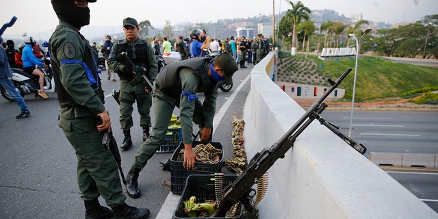 Soldiers take a position on an overpass next to the La Carlota air base in Caracas, Venezuela. (AP Photo/Ariana Cubillos)