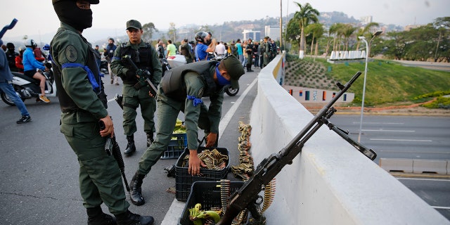 Soldiers take a position on an overpass next to the La Carlota air base in Caracas, Venezuela. (AP Photo/Ariana Cubillos)