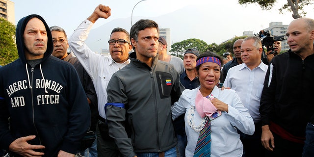 Opposition leader Leopoldo Lopez, center, is seen surrounded by supporters outside La Carlota air base in Caracas, Venezuela, Tuesday, April 30, 2019. Lopez, who had been under house arrest for leading an anti-government push in 2014, said he had been freed by soldiers and called for a military uprising. (AP Photo/Ariana Cubillos)