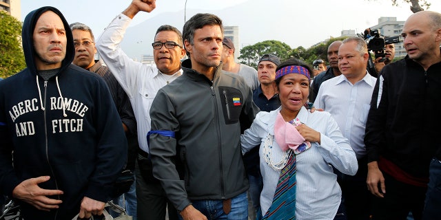 Opposition leader Leopoldo Lopez, center, is seen surrounded by supporters outside La Carlota air base in Caracas, Venezuela, Tuesday, April 30, 2019. Lopez, who had been under house arrest for leading an anti-government push in 2014, said he had been freed by soldiers and called for a military uprising.