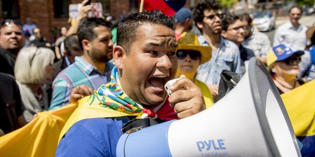 Supporters of opposition leader Juan Guaido supporters yelling chats toward pro-Maduro supporters outside of the Venezuelan Embassy in Washington on Tuesday. (AP Photo/Andrew Harnik)