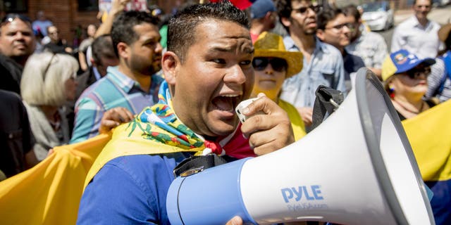 Supporters of opposition leader Juan Guaido supporters yelling chats toward pro-Maduro supporters outside of the Venezuelan Embassy in Washington on Tuesday. (AP Photo/Andrew Harnik)