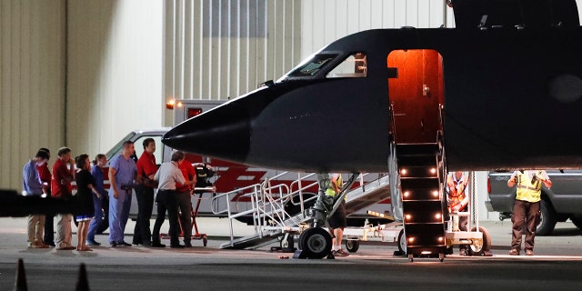 Medical personnel and visitors gather at the nose of a transport plane carrying Otto Warmbier at Lunken regional airport, Tuesday, June 13, 2017, in Cincinnati.