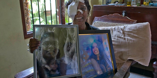 Anusha Kumari holds portraits of her daughter Sajini Venura Dulakshi and son Vimukthi Tharidu Appuhami, both victims of Easter Sunday's bomb blasts.