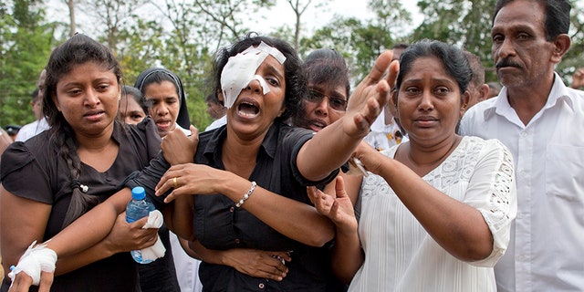 Anusha Kumari, second from left, weeps during a mass burial for her husband, two children and three siblings, all victims of Easter Sunday's bomb attacks, in Negombo, Sri Lanka.