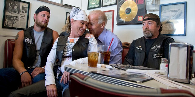 In this Sept. 9, 2012, file photo, Vice President Joe Biden talks to customers, including a woman who pulled up her chair in front of the bench Biden was sitting on, during a stop at Cruisers Diner in Seaman, Ohio. (AP Photo/Carolyn Kaster, File)