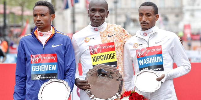 Men's race first place winner Kenya's Eliud Kipchoge, center, poses with second place winner Ethiopia's Mosinet Geremew, left, and third place winner Ethiopia's Mule Wasihun at the 39th London Marathon in London, Sunday, April 28, 2019. (AP Photo/Alastair Grant)