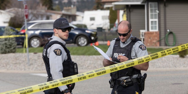 Royal Canadian Mounted Police officers work outside a scene in Penticton, British Columbia, Monday, April 15, 2019.