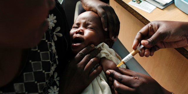 A mother holds her baby receiving a new malaria vaccine as part of a trial at the Walter Reed Project Research Center in Kombewa, Western Kenya, on Oct. 30, 2009.   (AP Photo/Karel Prinsloo, File)