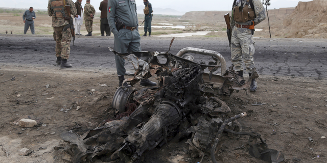 Afghan security forces gather at the site of Monday's suicide attack near the Bagram Air Base, north of Kabul, Afghanistan, Tuesday, April 9, 2019. Three American service members and a U.S. contractor were killed when their convoy hit a roadside bomb on Monday near the main U.S. base in Afghanistan, the U.S. forces said. The Taliban claimed responsibility for the attack. (AP Photo/Rahmat Gul)