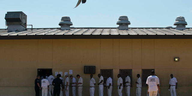 FILE - In this June 18, 2015, file photo, prisoners stand in a crowded lunch line during a prison tour at Elmore Correctional Facility in Elmore, Ala. The Justice Department has determined that Alabama's prisons are violating the Constitution by failing to protect inmates from violence and sexual abuse and by housing them in unsafe and overcrowded facilities, according to a scathing report Wednesday, April 3, 2019, that described the problems as "severe" and "systemic." (AP Photo/Brynn Anderson, File)