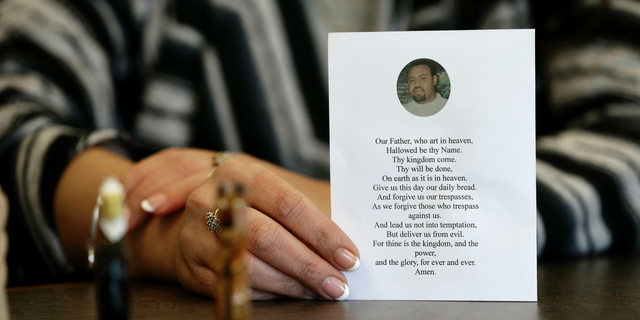 In this photo taken Wednesday, March 6, 2019 in Raleigh, N.C. Heather Allen holds a photo of her father, Lee Wayne Hunt, from his memorial. Even though Lee Wayne Hunt died as a prisoner found guilty of a double murder, his family says he never gave up hope of proving his innocence. (AP Photo/Gerry Broome)