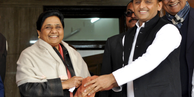 FILE - In this Jan. 15, 2019, file photo, Samajwadi Party President Akhilesh Yadav, right, greets Bahujan Samaj Party chief Mayawati on her birthday in Lucknow, India. Longtime political archrivals in India's most populous state have stitched an inventive political alliance that fuses votes from the ancient Hindu caste system to take on the ruling Hindu nationalist party-led government. (AP Photo/Nirala Tripathi)