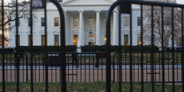 In this March 24, 2019 photo, The White House is seen behind security barriers in Washington. A White House official turned whistleblower says dozens of people in President Donald Trump’s administration were granted access to classified information despite “disqualifying issues” in their backgrounds including concerns about foreign influence, drug use and criminal conduct. (AP Photo/Cliff Owen)