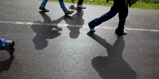 FILE - In this Aug. 14, 2012 file photo, Honduran migrants walk along a road after being deported by bus from Mexico to Corinto, Honduras, near the border with Guatemala. On Sunday, April 14, 2019, Mexican immigration officials said they have sent a group of just over 200 migrants back to Honduras, most of them families traveling with underage children, and that they were flown from the southeastern Mexican state of Veracruz to San Pedro Sula. (AP Photo/Esteban Felix, File)