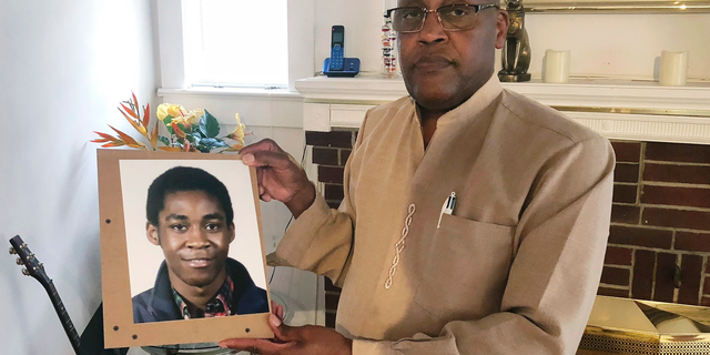Askia Khafra's father, Dia, holds a photo of his son in this Sept. 5, 2018 photo. (Associated Press)