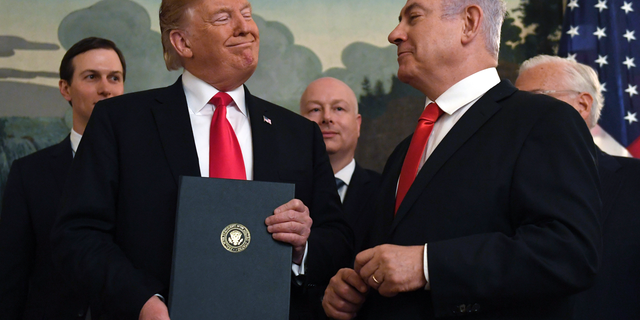 FILE - In this Monday, March 25, 2019 file photo, President Donald Trump smiles at Israeli Prime Minister Benjamin Netanyahu, right, after signing a proclamation in the Diplomatic Reception Room at the White House in Washington. Trump isn't on the ballot for Israel's national election, yet he's a dominant factor for many American Jews as they assess the high stakes of balloting on Tuesday, April 9, 2019. (AP Photo/Susan Walsh)