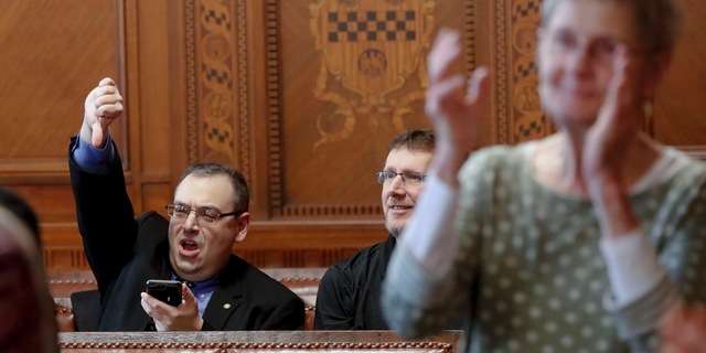 Val Finnell, left, gives a thumbs down, as other applaud after the Pittsburgh City Council voted 6-3 to pass gun-control legislation, Tuesday, April 2, 2019, in Pittsburgh. The bill, introduced in the wake of the synagogue massacre last October, places restrictions on military-style assault weapons like the AR-15 rifle that authorities say was used in the attack that killed 11 and wounded seven. (AP Photo/Keith Srakocic)