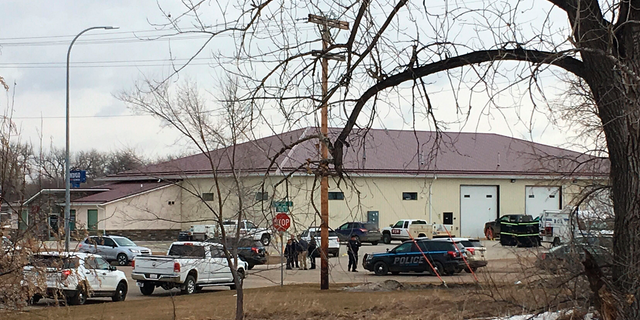Police vehicles are seen in the backside of RJR Maintenance and Management, a property management company, Monday, April 1, 2019, Mandan, N.D. Authorities say police responding to a medical call at the North Dakota business have found "several" bodies. The Mandan Police Department issued a three-sentence news release confirming that officers had found "several people who were deceased inside" the business in the city of about 22,000 just across the Missouri River west of Bismarck. (AP Photo/Blake Nicholson)