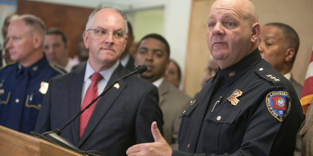 Louisiana State Fire Marshal H. "Butch" Browning speaks as Louisiana Gov. John Bel Edwards looks on during a press conference on the arrest of a suspect Holden Matthews for the arson of three churches in Opelousas, La., Thursday, April 11, 2019. (AP Photo/Lee Celano)