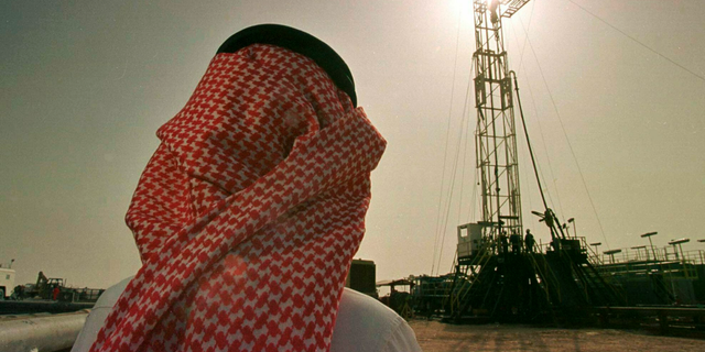 In this Feb. 26, 1997, file photo, Khaled al-Otaiby, an official of the Saudi oil company Aramco watches progress at a rig at the al-Howta oil field near Howta, Saudi Arabia. 