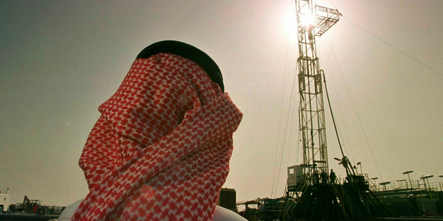 In this February 26, 1997 file photo, Khaled al-Otaiby, an employee of Saudi oil company Aramco, is monitoring progress on a rig in the al-Howta oil field near Howta, Saudi Arabia. 