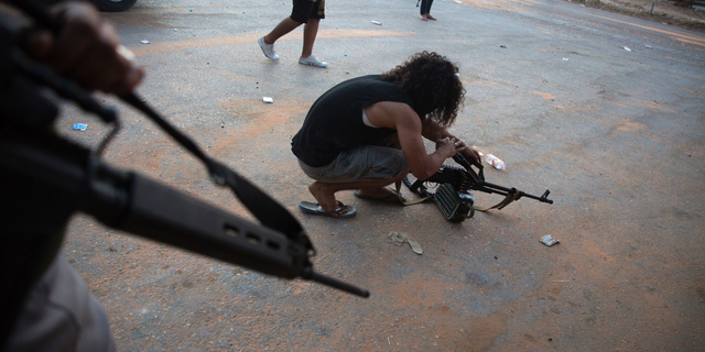 In this Sept. 21, 2018 file photo, a fighter under the UN-backed government prepares his gun during clashes in southern Tripoli, Libya.&nbsp;