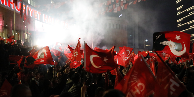 Supporters of the Republican People's Party, CHP, wave Turkish flags, and one with a portrait of Kemal Ataturk, right, as they celebrate after preliminary results of the local elections were announced in Ankara, Turkey, early Monday, April 1, 2019.