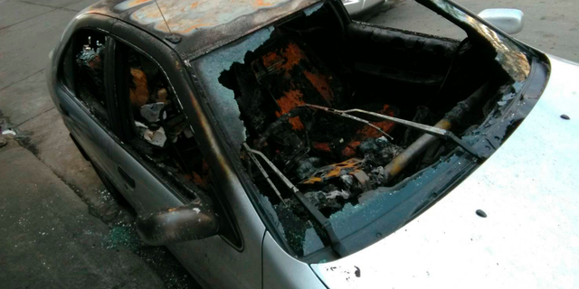 In this photo released by anti-military rule activist Ekachai Hongkangwan, the personal vehicle owned by Ekachai sits destroyed by fire on the side of a road early Monday, April 1, 2019, in Bangkok, Thailand, hours after he attended a rally calling the recent general elections mismanaged. Ekachai has been the repeated target of physical and legal attacks, including a previous one on his car that did less damage. On March 5, he was attacked by two unidentified men on a motorcycle who tried to beat him with a wooden stick and a metal pipe. (Ekachai Hongkangwan via AP)