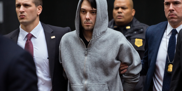 FILE - In this Dec. 17, 2015, file photo, Martin Shkreli, the former hedge fund manager under fire for buying a pharmaceutical company and ratcheting up the price of a life-saving drug, is escorted by law enforcement agents in New York, after being taken into custody following a securities probe. Pharmaceutical honcho Shkreli has been banished to solitary confinement amid allegations he was running his drug company from federal prison using a contraband smartphone, a person familiar with the matter told The Associated Press. (AP Photo/Craig Ruttle, File)