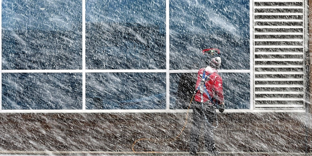 Xavier Castillo of Endres Window Cleaning finishes up a set of windows on the Profinium building in downtown Mankato, Minn., as snow falls Wednesday, Apr. 10, 2019. (Pat Christman/The Free Press via AP)