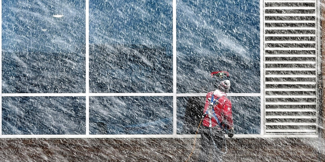 Xavier Castillo of Endres Window Cleaning finishes up a set of windows on the Profinium building in downtown Mankato, Minn., as snow falls Wednesday, Apr. 10, 2019. (Pat Christman/The Free Press via AP)