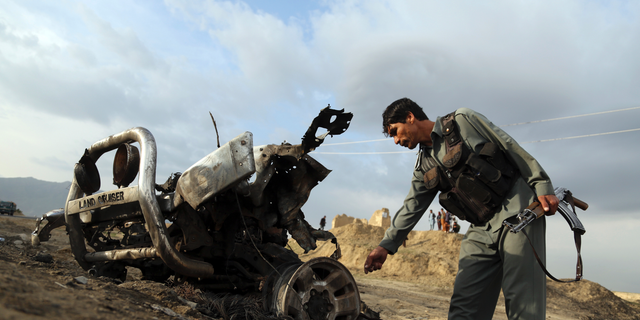 An Afghan security force check the site a day after an an attack near the Bagram Air Base, north of Kabul, Afghanistan, Tuesday, April 9, 2019. Three American service members and a U.S. contractor were killed when their convoy hit the roadside bomb on Monday near the main U.S. base in Afghanistan, the U.S. forces said. The Taliban claimed responsibility for the attack. (AP Photo/Rahmat Gul)
