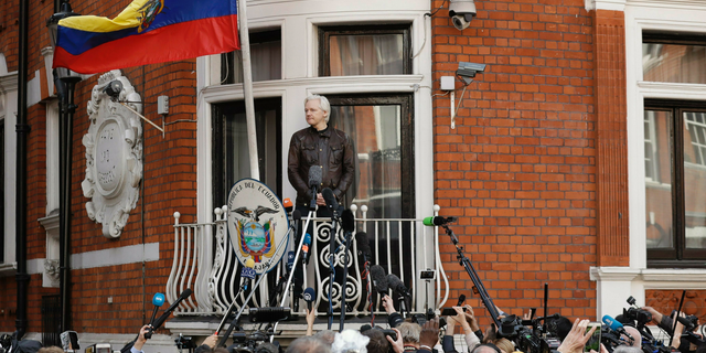 FILE - In this file photo dated Friday May 19, 2017, watched by the media WikiLeaks founder Julian Assange looks out from the balcony of the Ecuadorian embassy prior to speaking, in London. London police say they've arrested WikiLeaks founder Julian Assange at the Ecuadorian embassy, it was reported on Thursday, April 11, 2019. (AP Photo/Matt Dunham, File)