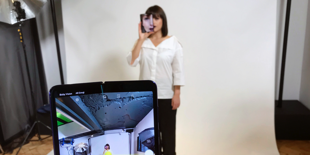 FILE - In this April 16, 2019, file photo, a model holds a Samsung Galaxy Fold smart phone to her face, during a media preview event in London. Samsung is pushing back this week's planned public launch of its highly anticipated folding phone after reports that reviewers' phones were breaking. The company had been planning to release the Galaxy Fold on Friday. Instead, it says it will to run more tests and announce a new launch date in the coming weeks. (AP Photo/Kelvin Chan, File)