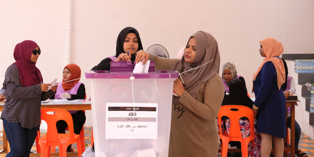 Madivian women cast their votes in Male, Maldives, Saturday, April 6, 2019. Voting is underway in the Maldives in a parliamentary election many hope would help President Ibrahim Mohammed Solih to overcome a coalition split that has hampered his efforts to restore political freedoms and tackle corruption. (AP Photo/Mohamed Sharuhaan)