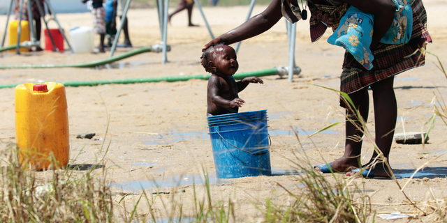 A mother bathing her baby in a bucket at a camp for displaced survivors of Cyclone Idai in Beira, Mozambique, last month. (AP Photo/Tsvangirayi Mukwazhi, File)