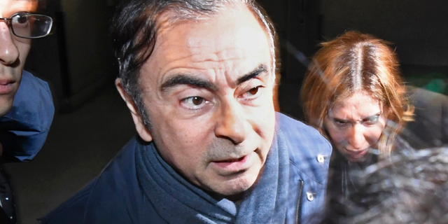 FILE - In this April 3, 2019, file photo, former Nissan Chairman Carlos Ghosn, center, leaves his lawyer's office in Tokyo. Nissan Chief Executive Hiroto Saikawa has apologized to shareholders for the unfolding scandal at the Japanese automaker and asked for their approval to oust from the board former Chairman Ghosn, who has been arrested on financial misconduct charges. Saikawa and other Nissan Motor Co. executives bowed deeply at a Tokyo hotel Monday, April 8, 2019, where the extraordinary shareholders' meeting was being held. (Sadayuki Goto/Kyodo News via AP, File)