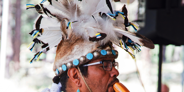 This 2017 photo provided by the Museum of Northern Arizona shows an unidentified man wearing a headpiece fashioned out of an animal hide at the Navajo Festival of Arts and Culture in Flagstaff, Ariz. The hide did not come from a state wildlife repository, but the photo shows how Native Americans use animal parts for religious and cultural purposes. Arizona wildlife officials are on the lookout for bear, bison, badger and other carcasses for Native Americans' religious and cultural use under a unique new program that allows tribes to make requests for various animal parts. (Ryan Williams/Museum of Northern Arizona via AP)