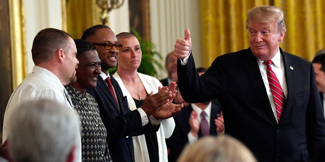 President Donald Trump gestures to Troy Powell, left, at the 2019 Prison Reform Summit and First Step Act Celebration in the East Room of the White House in Washington, April 1, 2019. (AP Photo/Susan Walsh)