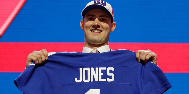 Quarterback Daniel Jones poses with his new jersey after the New York Giants chose Jones in the first round of the NFL football game on Thursday, April 25, 2019, in Nashville, Tennessee (Photo AP / Mark Humphrey)