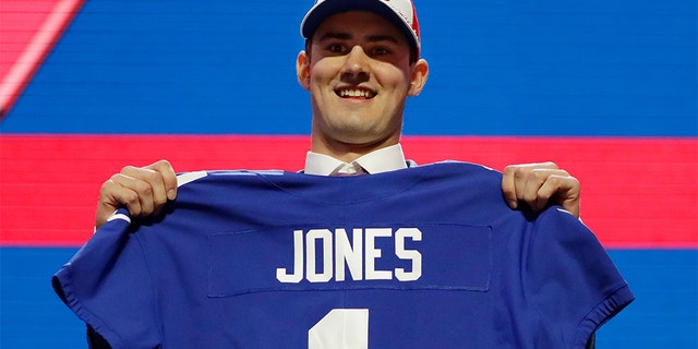 Duke quarterback Daniel Jones poses with his new jersey after the New York Giants selected Jones in the first round at the NFL football draft, Thursday, April 25, 2019, in Nashville, Tenn. (AP Photo/Mark Humphrey)