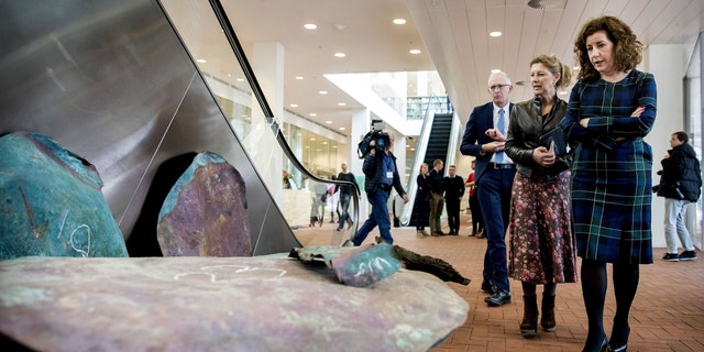 Dutch minister of Culture Ingrid van Engelshoven (R) stands in front of copper plates from the 16th-century shipwreck.