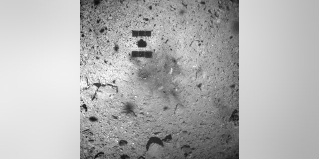 REPORT - On February 22, 2019, a file image published by the Japan Aerospace Exploration Agency (JAXA) shows the center, center, shadow of the Hayabusa2 probe after it successfully hit the asteroid Ryugu.