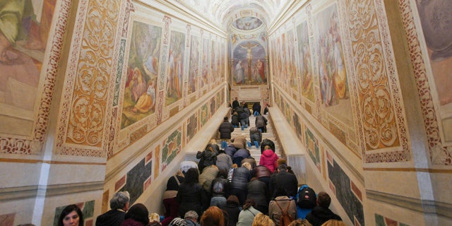Faithful kneel on the newly restored Holy Stairs (Scala Sancta), which according to Catholic Church is the stair on which Jesus Christ stepped leading on his way to the crucifixion, during a special opening, in Rome, Thursday, April 11, 2019. These original marble steps will be accessible until June 9, 2019, the Feast of the Pentecost, after witch their walnut wood covering, wanted by Pope Innocent XIII in 1723 to protect them, will be repositioned. (AP Photo/Andrew Medichini)